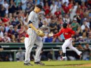 Seattle Mariners starting pitcher Mike Montgomery tosses a new ball in the air as Boston Red Sox's Rusney Castillo, right, rounds the bases after his two-run home run during the first inning at Fenway Park in Boston Friday, Aug. 14, 2015.