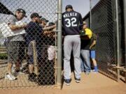 Seattle Mariners' Taijuan Walker signs autographs during spring training baseball practice Saturday, Feb. 21, 2015, in Peoria, Ariz.