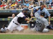 Seattle Mariners' Logan Morrison, right, scores on a single by Mariners' Austin Jackson as Minnesota Twins catcher Kurt Suzuki, left, bobbles the throw from left field during the 11th inning Sunday at Minneapolis. The Mariners won 4-1.