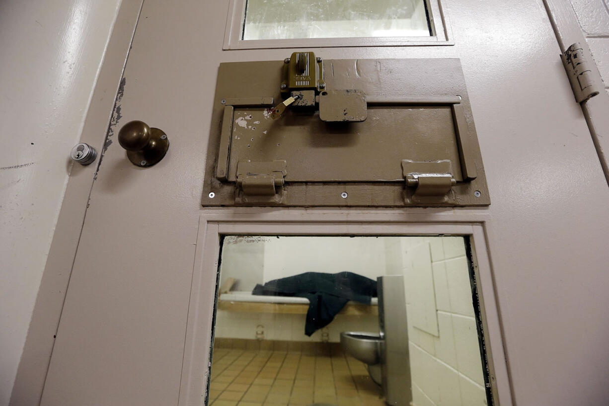 An inmate huddles Oct. 15 under a heavy blanket on a bunk in the psychiatric unit of the Pierce County Jail in Tacoma.