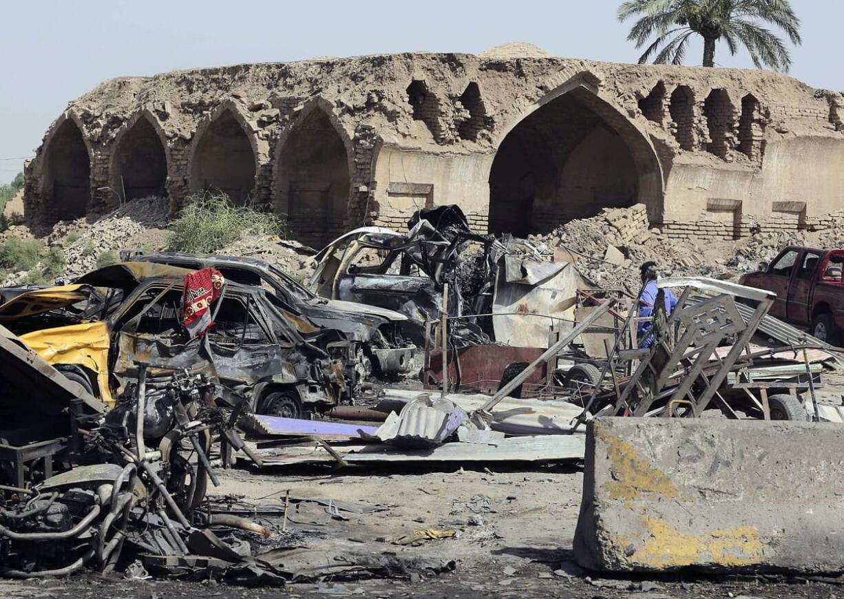 A man walks Saturday amid the debris from a Friday night suicide car bombing at a busy market in Khan Beni Saad, about 20 miles northeast of Baghdad, Iraq.