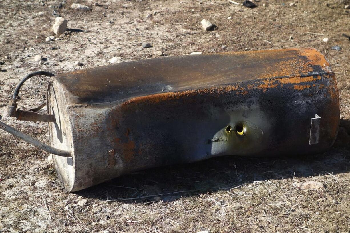 In this undated photo, a piece of debris that Kurdistan officials say is a gas canister lies at the site of a bomb attack on a road between Mosul and the Syrian border in northern Iraq.