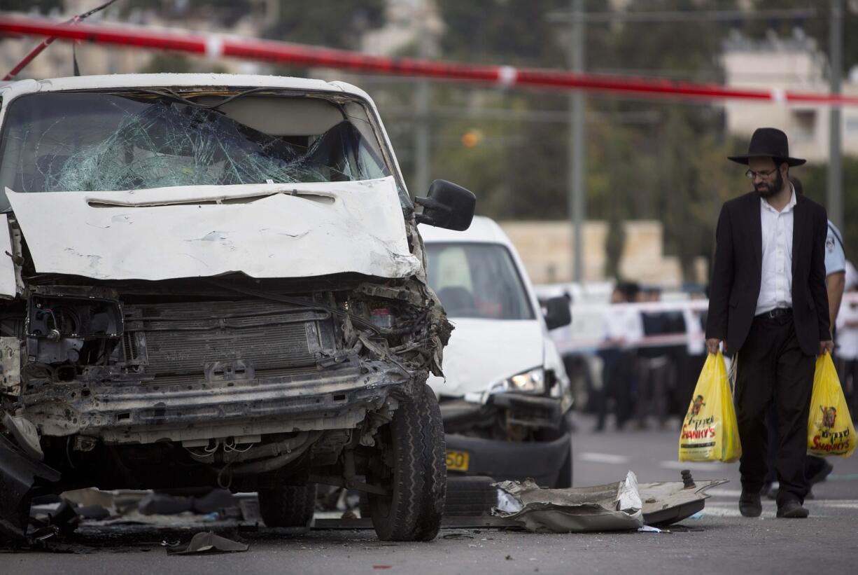 An ultra-Orthodox Jewish man walks at the scene of an attack Wednesday in Jerusalem.