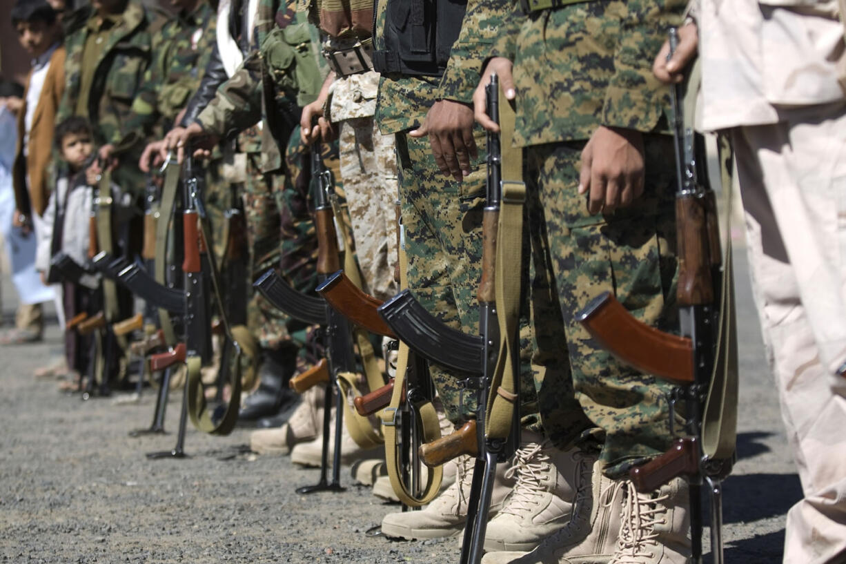 Houthi Shiite Yemenis wearing army uniforms hold their weapons during a rally Wednesday to show support for their comrades in Sanaa, Yemen.