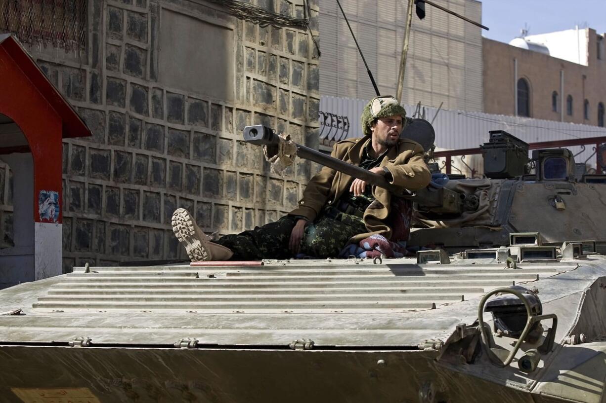 A Houthi Shiite Yemeni wearing army uniform sits atop an armored vehicle, which was seized from the army during recent clashes, outside the house of Yemen's President Abed Rabbo Mansour Hadi in Sanaa, Yemen, on Thursday.