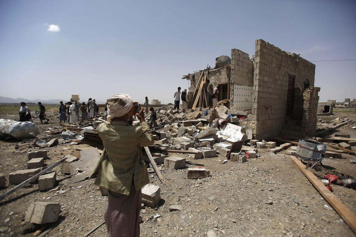 A boy uses his mobile to take pictures of the rubble of houses destroyed by a Saudi-led airstrike on the outskirts of Sanaa, Yemen, Wednesday, June 3, 2015. The Saudi-led coalition launched new strikes on Houthi positions in Sanaa, rocking residential areas. The strikes, as well as Saudi-led air and sea blockade, have caused food, water and medicine shortages, sparking a humanitarian crisis in the country.