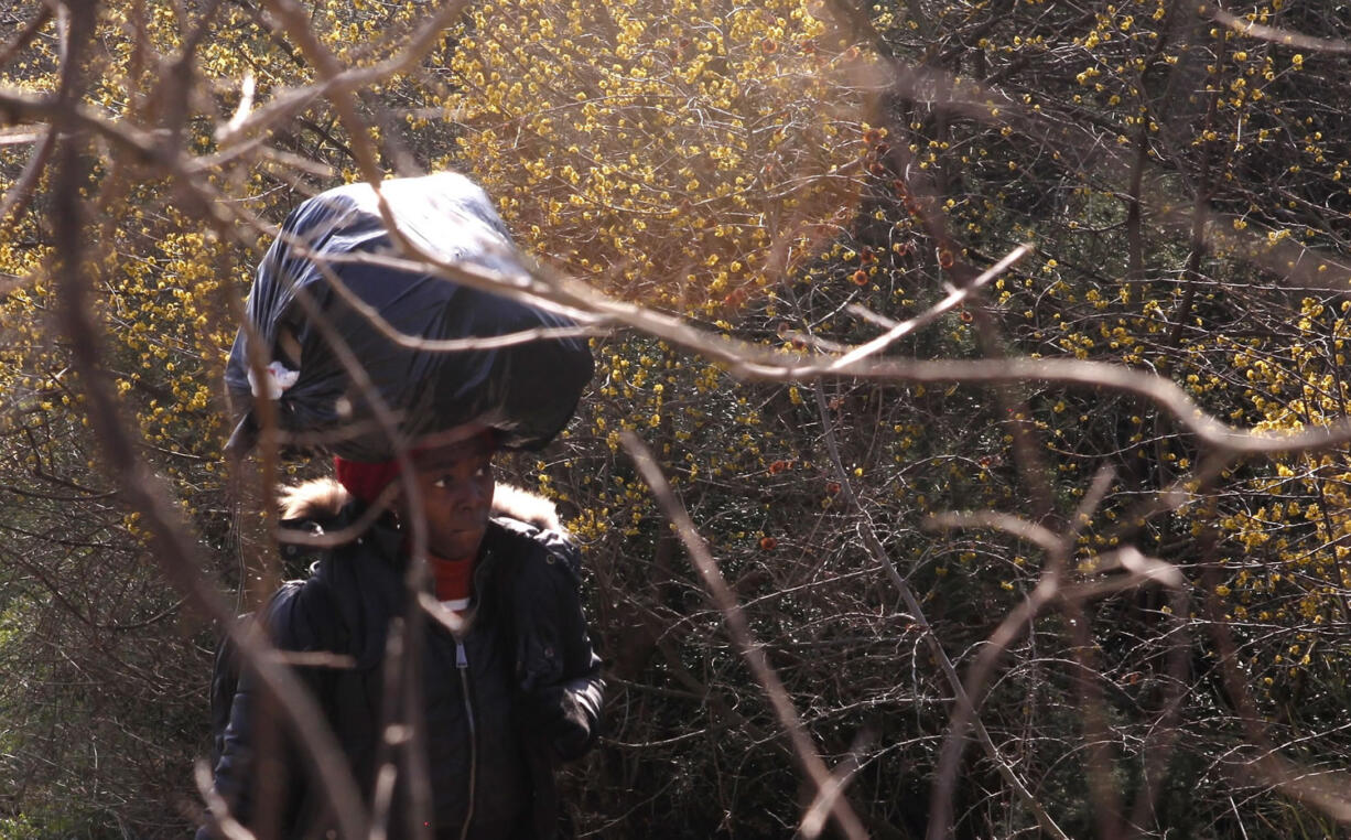 Sandrine, from Cameroon, carries her belongings on her head Feb.