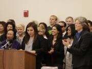 Teresa Mosqueda of the Washington State Labor Council, at podium, is joined by lawmakers and other supporters at a news conference in Olympia on Monday before a hearing on a bill to raise the state's minimum wage to $12 an hour over the next four years.