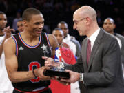 NBA Commissioner Adam Silver, right, hands West Team's Russell Westbrook the MVP trophy after the NBA All-Star Game, Sunday, Feb. 15, 2015, in New York.