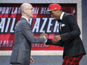 Rondae Hollis-Jefferson, right, greets NBA Commissioner Adam Silver after being selected 23rd overall by the Portland Trail Blazers during the NBA draft, Thursday, June 25, 2015, in New York.