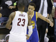 Cleveland Cavaliers forward LeBron James (23) hugs Golden State Warriors guard Stephen Curry (30) during the second half of Game 6 of basketball's NBA Finals in Cleveland, Tuesday, June 16, 2015. The Warriors defeated the Cavaliers 105-97 to win the best-of-seven game series 4-2.