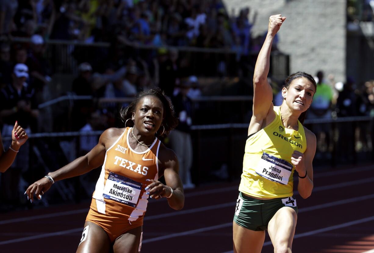 Oregon's Jenna Prandini, right, celebrates winning the women's 100 meters ahead of Texas' Morolake Akinosun during the NCAA track and field championships in Eugene, Ore., Saturday, June 13, 2015. Akinosun finished second.