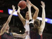 Tennessee's Cierra Burdick, center, shoots against Gonzaga's Sunny Greinacher (14) and Emma Wolfram (12) during the first half of the regional semifinal game in the NCAA tournament, Saturday, March 28, 2015, in Spokane.