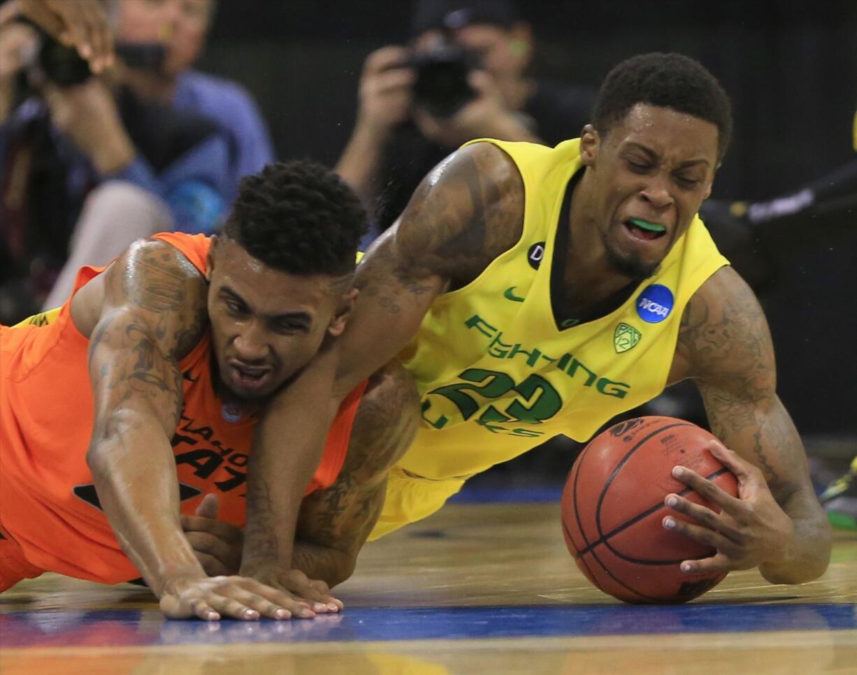 Oregon's Elgin Cook, right, and Oklahoma State's Le'Bryan Nash (2) go after a loose ball during the first half of an NCAA tournament game in Omaha, Neb., Friday.