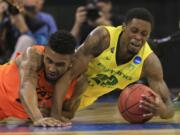 Oregon's Elgin Cook, right, and Oklahoma State's Le'Bryan Nash (2) go after a loose ball during the first half of an NCAA tournament game in Omaha, Neb., Friday.