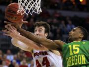 Oregon's Jalil Abdul-Bassit (15) and Wisconsin's Frank Kaminsky (44) compete for a rebound during the second half of an NCAA tournament game in Omaha, Neb., Sunday, March 22, 2015.