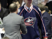 Portland Winterhawks winger Paul Bittner shakes hands with an executive after being chosen 38th overall by the Columbus Blue Jackets during the second round of the NHL draft on Saturday, June 27, 2015, in Sunrise, Fla.