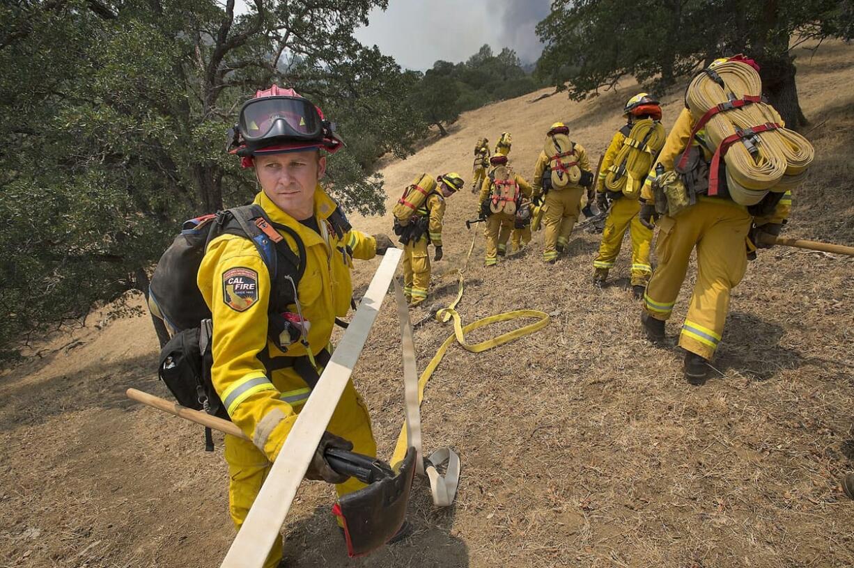 Cal Fire crews extend hose lines on the Wragg Fire on Thursday near Winters, Calif., east of Lake Berryessa.