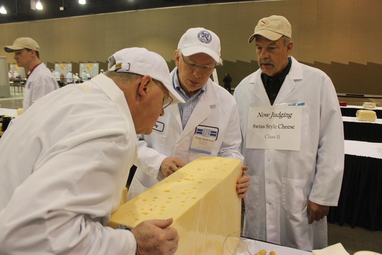 From left,  judges Doug Anker and Greg Anderson, and volunteer Steve Stettler inspect a swiss cheese during the 2015 United States Championship Cheese Contest on Tuesday in Milwaukee.