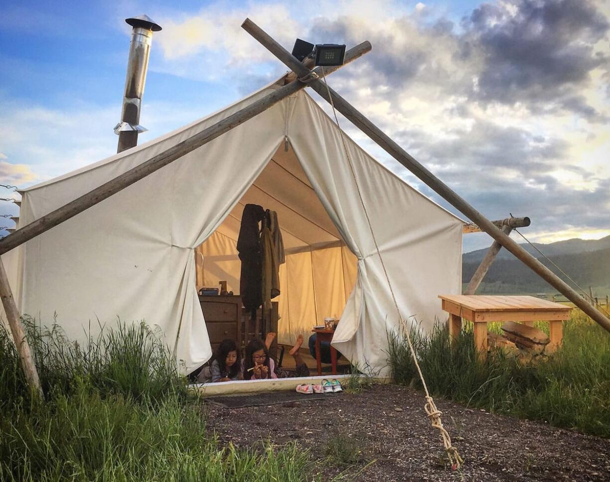 Kyra Melchor, 5, right, and her sister Elly Melchor, 9, relax inside a &quot;glamping&quot; tent in West Yellowstone, Mont.