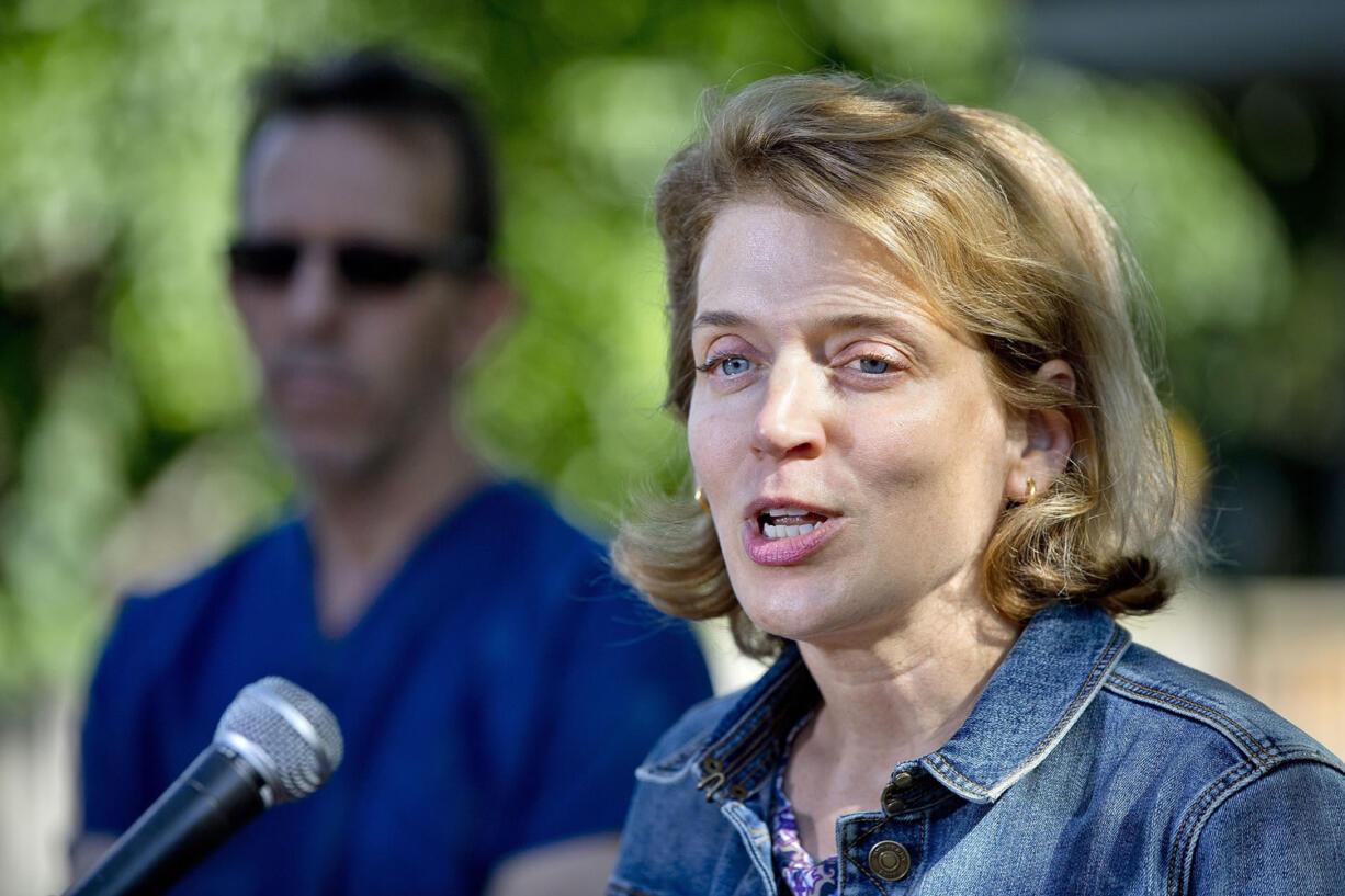 Brandie Smith, associate director of Animal Care Sciences at the Smithsonian's National Zoo, speaks Wednesday at the zoo in Washington. The zoo announced Friday that the surviving panda cub is male and the son of the zoo's male panda Tian Tian. Mei Xiang gave birth to fraternal twins Saturday, but the smaller cub -- also a male fathered by Tian Tian -- died Wednesday.