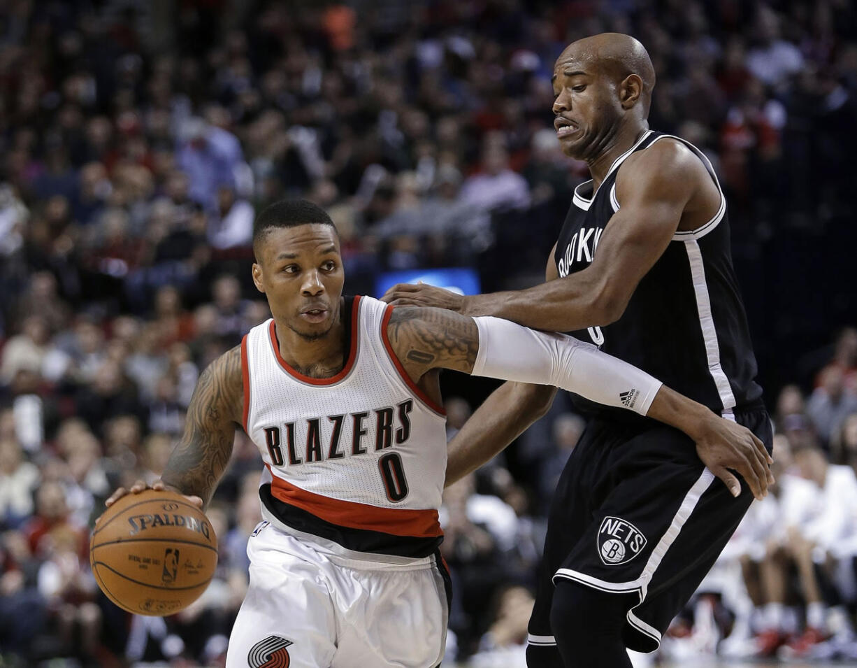 Portland Trail Blazers guard Damian Lillard, left, drives against Brooklyn Nets' Jarrett Jack during the second half Saturday, Nov. 15, 2014. Lillard led the Trail Blazers in scoring with 28 points as they won 97-87.