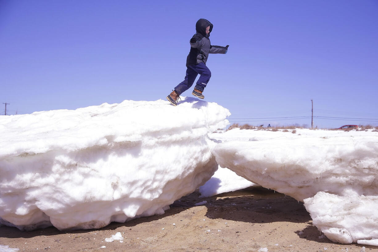 Cylus Kellereher, 7, of Portsmouth, N.H., runs along the top of large chunks of sea ice left on Wellfleet Harbor Beach at low tide Thursday in Wellfleet, Mass.