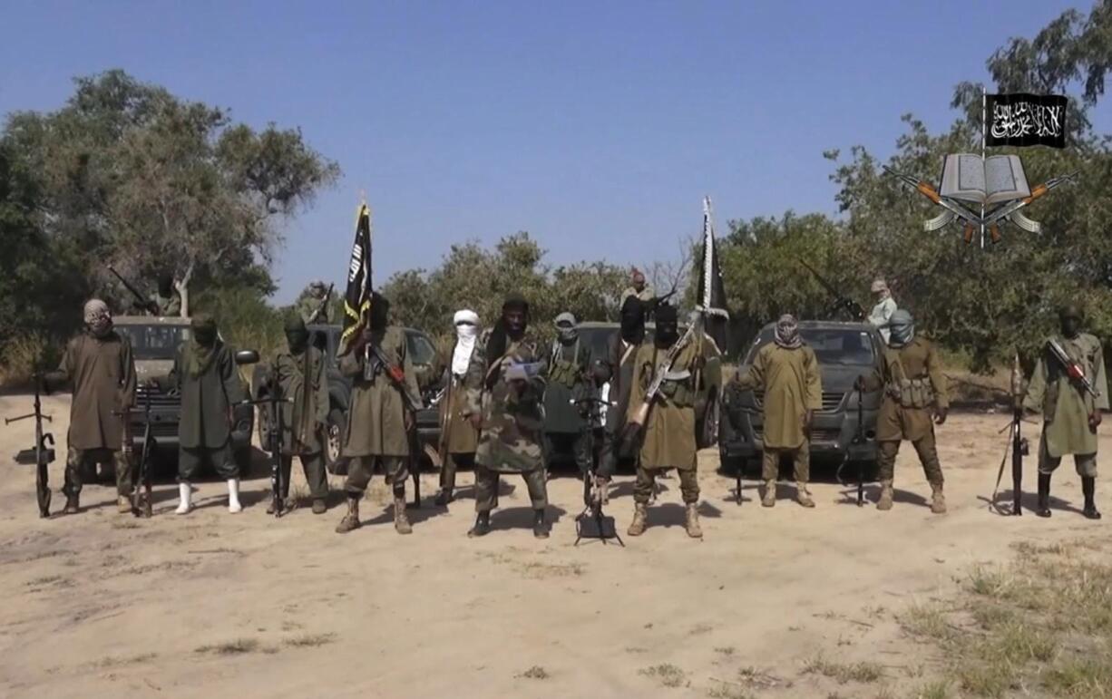 Boko Haram/Associated Press
Abubakar Shekau, center, the leader of Nigeria's Boko Haram group, is seen Oct. 31. Boko Haram fighters have shot or burned to death at least 91 civilians and wounded 500 in ongoing fighting in a Cameroonian border town near Nigeria, officials in Cameroon said.