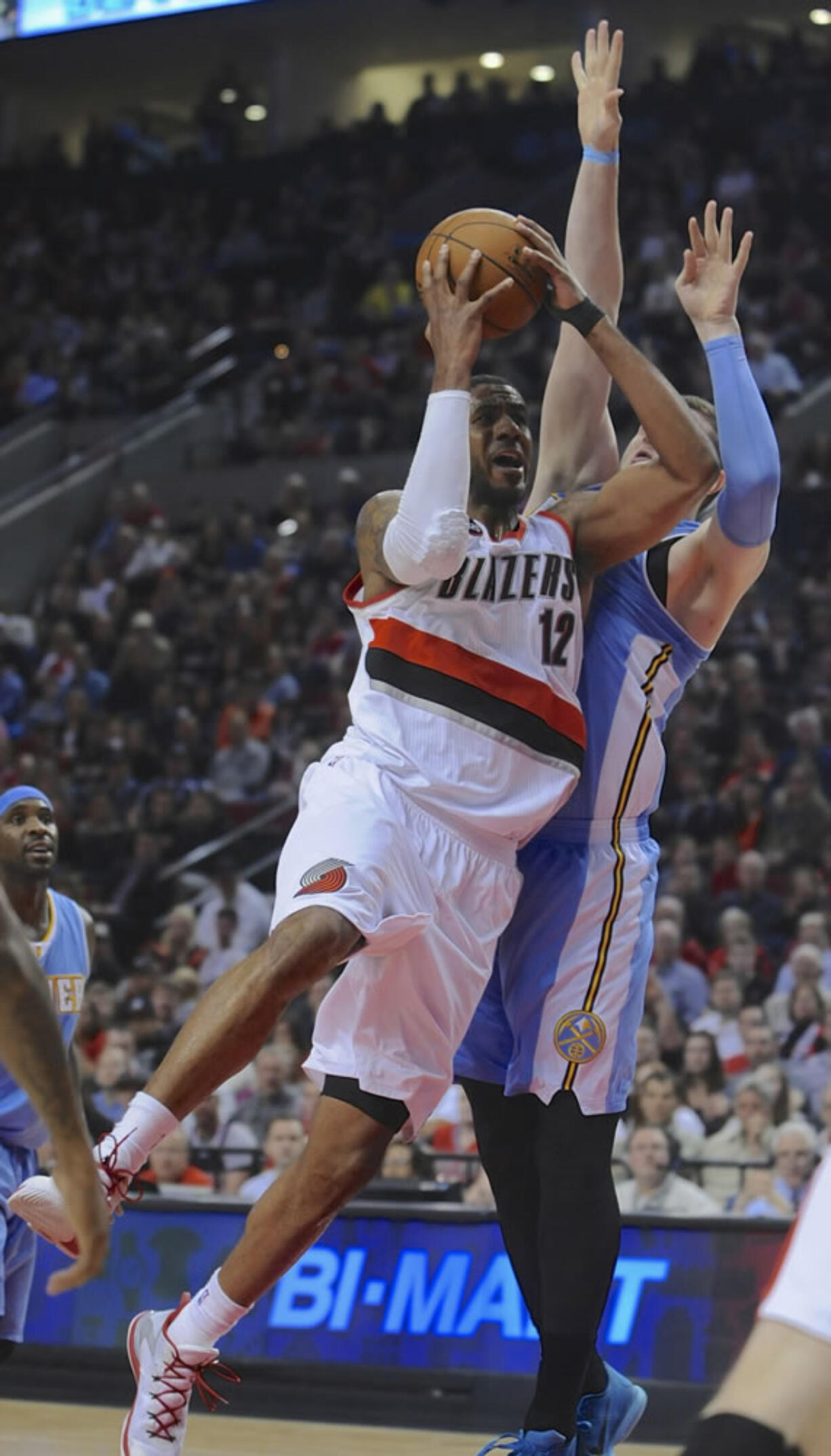 Portland Trail Blazers' LaMarcus Aldridge (12) shoots against Denver Nuggets' Jusuf Nurkic, right, during the second half Saturday, March 28, 2015. Aldridge had a team-high 32 points as the Trail Blazers defeated the Nuggets 120-114.