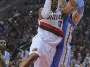 Portland Trail Blazers' LaMarcus Aldridge (12) shoots against Denver Nuggets' Jusuf Nurkic, right, during the second half Saturday, March 28, 2015. Aldridge had a team-high 32 points as the Trail Blazers defeated the Nuggets 120-114.