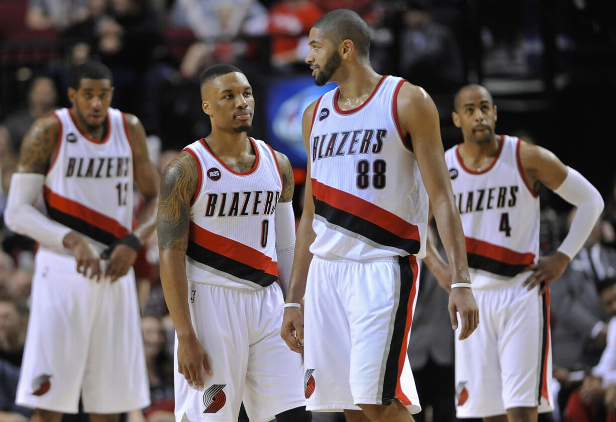 Portland Trail Blazers' Damian Lillard (0) talks with Nicolas datum (88) as they return to the court during the second half of an NBA basketball game against the Denver Nuggets in Portland, Ore., Saturday, March 28, 2015. The Trail Blazers won 120-114.