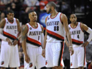 Portland Trail Blazers' Damian Lillard (0) talks with Nicolas datum (88) as they return to the court during the second half of an NBA basketball game against the Denver Nuggets in Portland, Ore., Saturday, March 28, 2015. The Trail Blazers won 120-114.