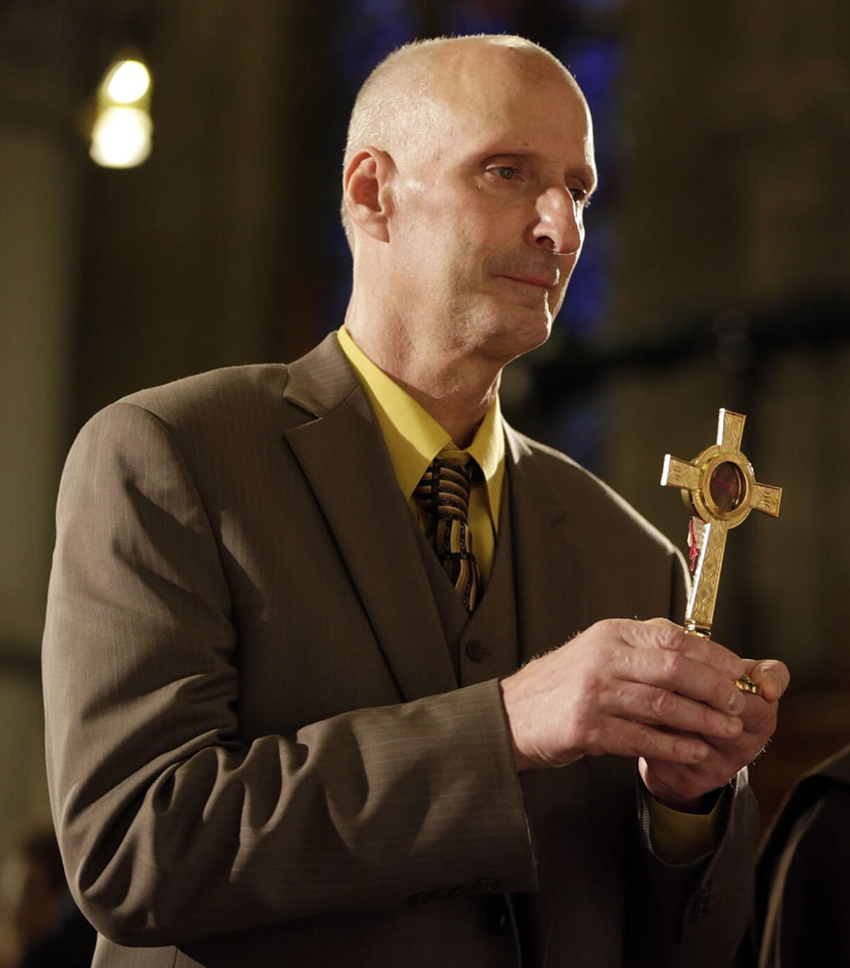 Michael Mencer holds a cross with a lock of hair of the Sister Miriam Teresa Demjanovich during a beatification ceremony for the nun at Cathedral Basilica of the Sacred Heart, Saturday, Oct. 4, 2014, in Newark, N.J. Demjanovich, who died in 1927 at age 26, is credited with curing Mencer's eye disease as a boy when he was given a lock of the nun's hair and prayed to her. The ceremony moves Demjanovich a step closer to sainthood with her beatification as it is the third in a four-step process.