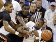 Washington's Mike Anderson, front right, and Oregon State's Gary Payton II, left, and Daniel Gomis reach for a loose ball in the first half Thursday, Jan. 15, 2015, in Seattle.