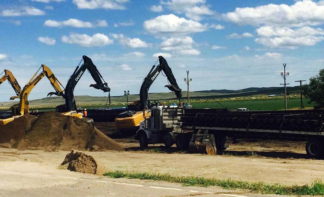 Crews with cranes attempt to raise derailed oil tanker cars near Culbertson, Mont., Friday, July 17, 2015. The tank cars were hauling fuel from North Dakota and derailed Thursday in rural northeastern Montana, authorities said.