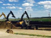 Crews with cranes attempt to raise derailed oil tanker cars near Culbertson, Mont., Friday, July 17, 2015. The tank cars were hauling fuel from North Dakota and derailed Thursday in rural northeastern Montana, authorities said.