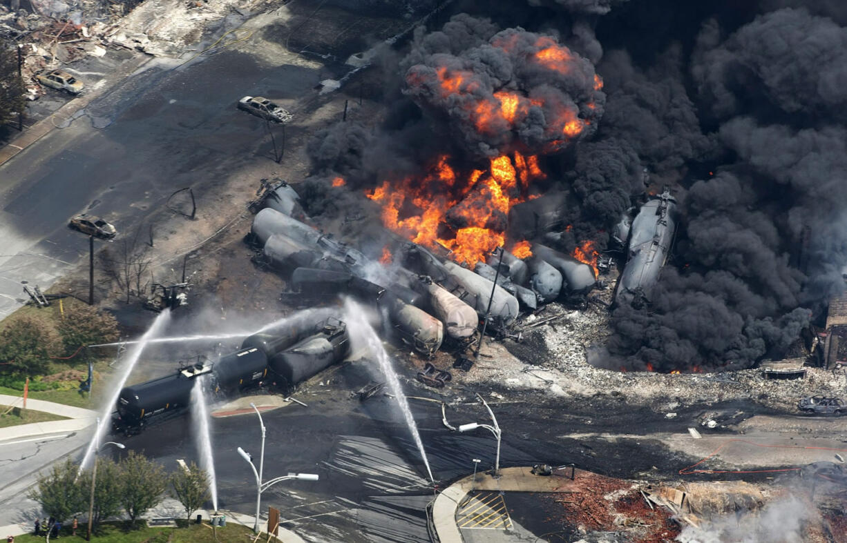 Smoke rises from railway cars carrying crude oil after derailing in downtown Lac Megantic, Quebec, on July 6, 2013. American Petroleum Institute President Jack Gerard said Tuesday that the oil and railroad industries are urging federal regulators to allow them as long as seven years to retrofit existing tank cars that transport highly volatile crude oil.