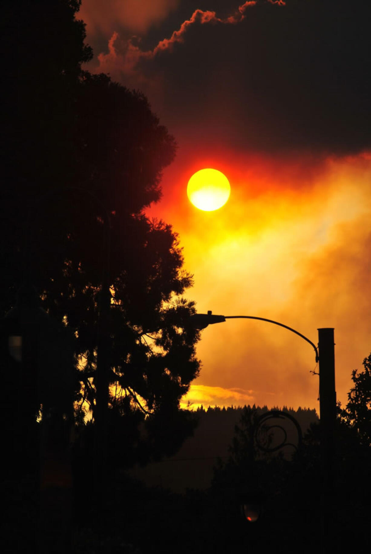 Smoke from the Scoggins Creek fire north of Hagg Lake clouds the sun from downtown Forest Grove, Ore., on Friday, Sept. 19, 2014.