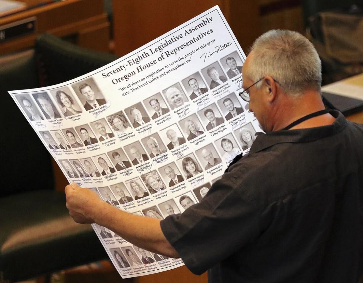 Rep. Chris Gorsek, D-Troutdale, looks over a photo collection of the House of Representatives on Monday at the state Capitol in Salem, Ore.