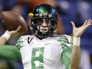 Oregon's Marcus Mariota warms up for the Valero Alamo Bowl NCAA college football game against Texas in San Antonio on Dec. 30, 2013. All eyes will be on Mariota when the Ducks take the field this season.