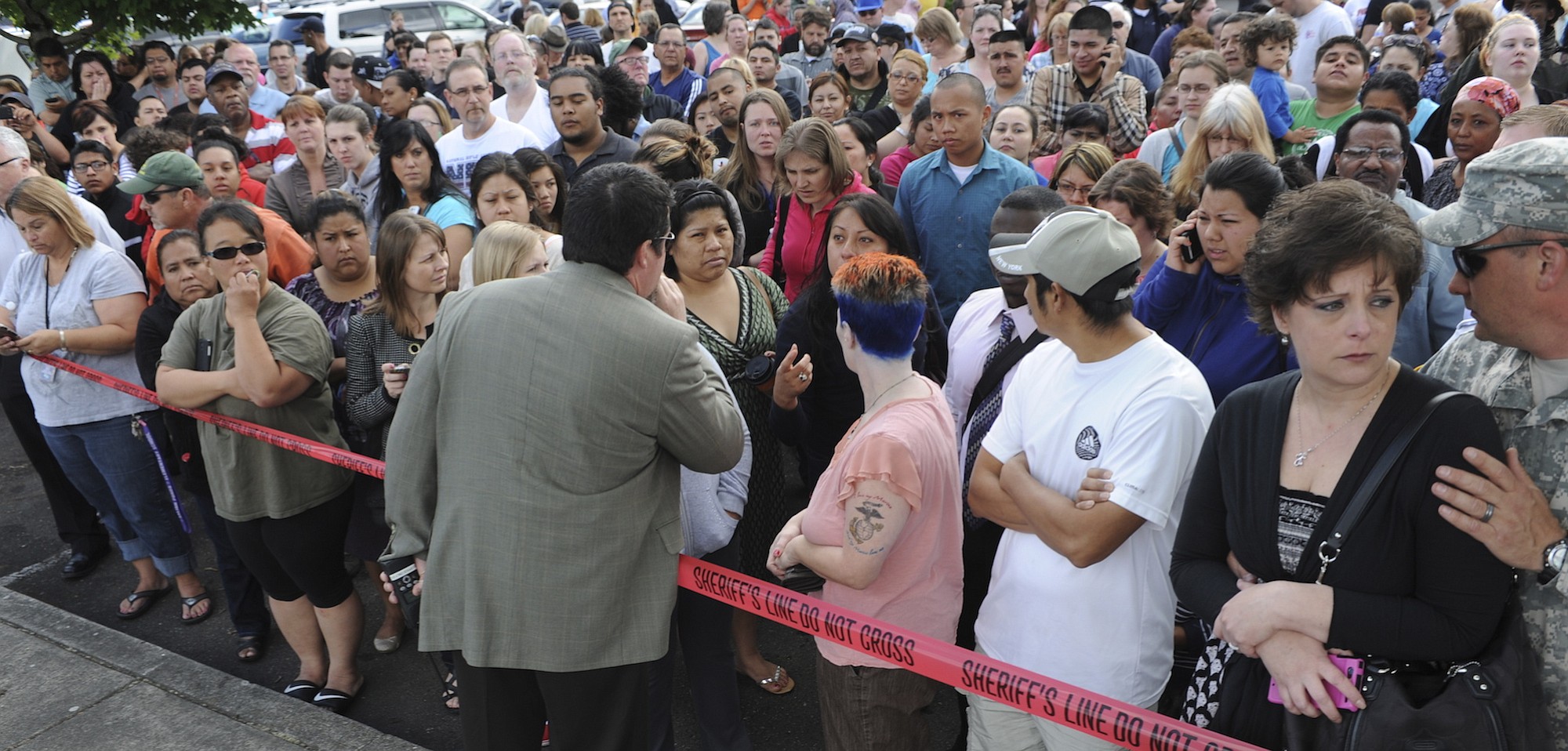 An official explains the procedures to reunite parents with their students as they wait at a shopping center parking lot in Wood Village, Ore., to be reunited after a shooting at Reynolds High School on Tuesday in nearby Troutdale.