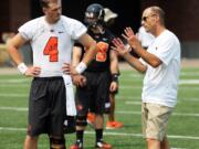 Oregon State's Sean Mannion and coach Mike Riley talk during the team's practice Monday, Aug. 4, 2014, in Corvallis, Ore.