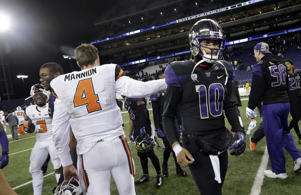 Washington quarterback Cyler Miles (10) gets a pat from Oregon State quarterback Sean Mannion after an NCAA college football game Saturday, Nov. 22, 2014, in Seattle. Washington won 37-13.