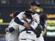 Seattle Mariners starting pitcher Hisashi Iwakuma, center, is mobbed by teammates, including catcher Jesus Sucre (2), after Iwakuma threw a no-hitter against the Baltimore Orioles in a baseball game Wednesday, Aug. 12, 2015, in Seattle. The Mariners won 3-0. (AP Photo/Ted S.