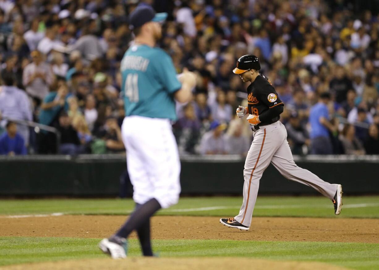 Seattle Mariners pitcher Charlie Furbush, left, stands on the mound as Baltimore Orioles' Chris Davis rounds the bases after hitting a solo home run in the 10th inning Friday.