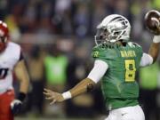 Oregon's Marcus Mariota, right, passes against Arizona during the first half of the Pac-12 Conference championship on Friday, Dec. 5, 2014, in Santa Clara, Calif.