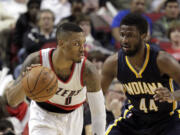 Portland Trail Blazers guard Damian Lillard, left, drives against Indiana Pacers forward Solomon Hill during the second half Thursday, Dec. 4, 2014. Lillard led the Trail Blazers in scoring with 23 points as they beat the Pacers 88-82.