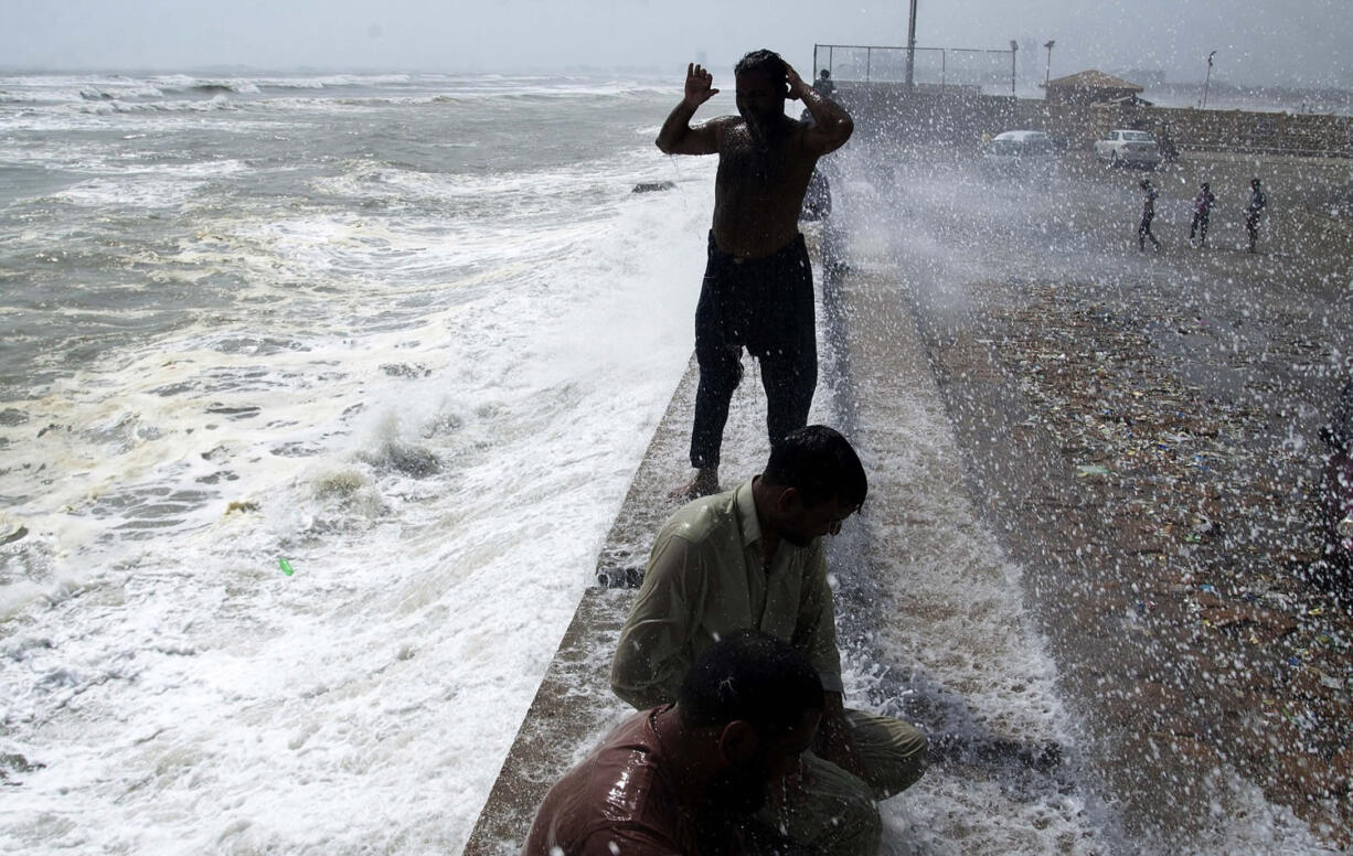 People cool themselves off at Karachi's shore in Pakistan, Tuesday.