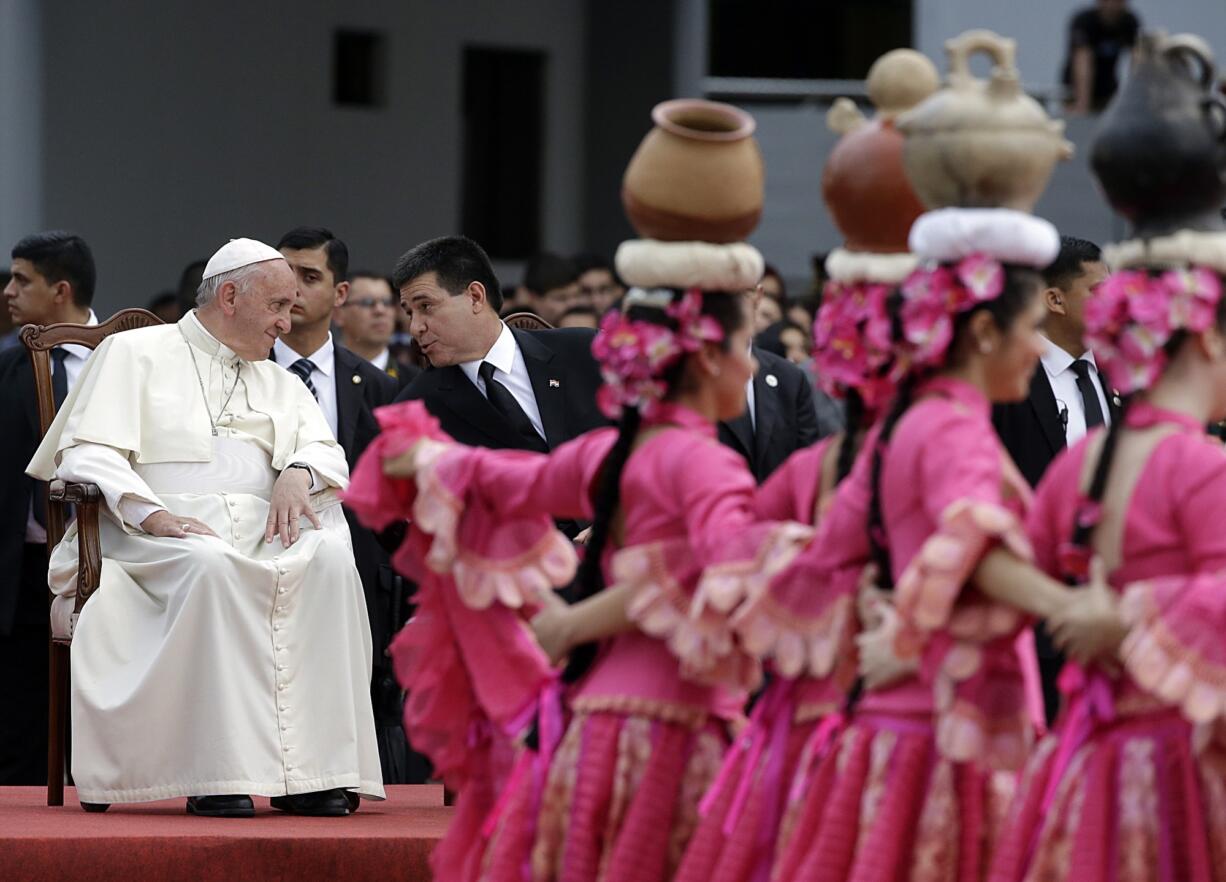 Pope Francis talks with Paraguay's President Horacio Cartes as they attend a welcome ceremony Friday at Silvio Pettirossi International airport in Asuncion, Paraguay.