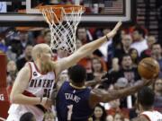 New Orleans Pelicans guard Tyreke Evans, right, drives to the hoop against Portland Trail Blazers center Chris Kaman during the first half in Portland, on Saturday, April 4, 2015.